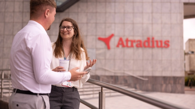 Woman and man have coffee break outside at the entrance of the Cardiff office