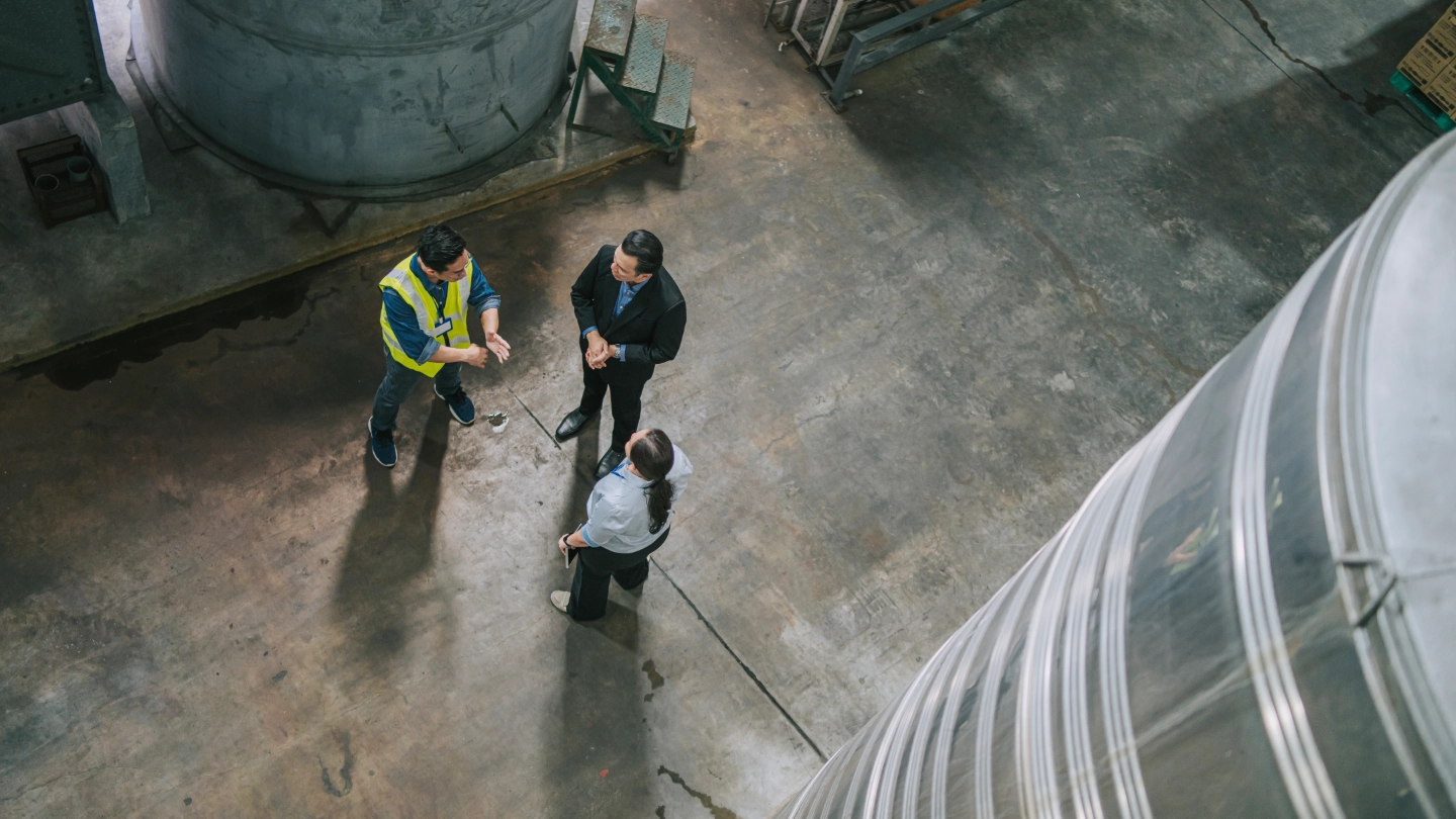 Workers having a discussion in a large warehouse Workers having a discussion in a large warehouse